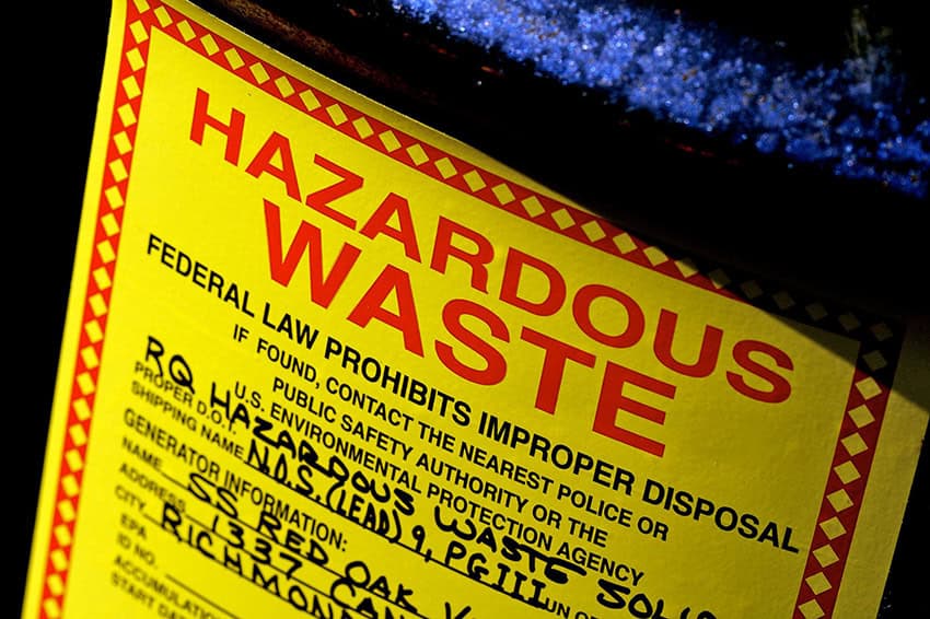 A hazardous waste barrel with a warning label