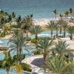 Palms surround an irregularly shaped pool next to the ocean at Hilton's Conrad hotel in Punta Mita.