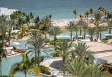 Palms surround an irregularly shaped pool next to the ocean at Hilton's Conrad hotel in Punta Mita.