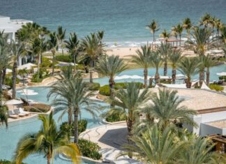 Palms surround an irregularly shaped pool next to the ocean at Hilton's Conrad hotel in Punta Mita.