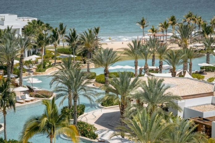 Palms surround an irregularly shaped pool next to the ocean at Hilton's Conrad hotel in Punta Mita.