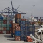 Shipping containers in many different colors waiting in stacks to be loaded at the Port of Enenada.