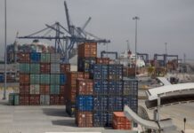 Shipping containers in many different colors waiting in stacks to be loaded at the Port of Enenada.