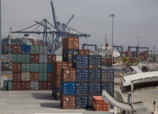 Shipping containers in many different colors waiting in stacks to be loaded at the Port of Enenada.