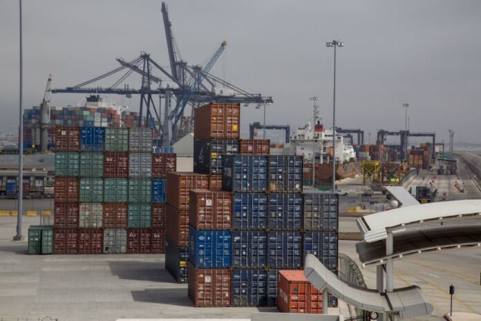 Shipping containers in many different colors waiting in stacks to be loaded at the Port of Enenada.