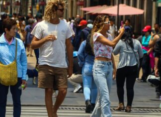 National and foreign tourists visit the Zócalo on this warm and semi-empty Sunday