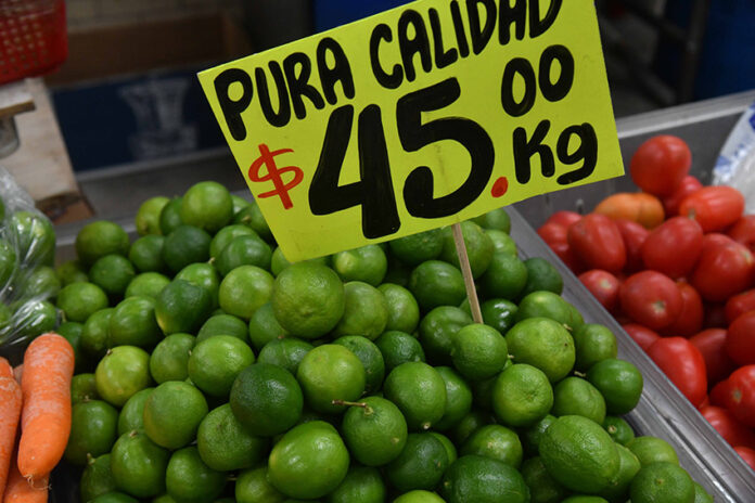 A pile of limes with a sign that reads 