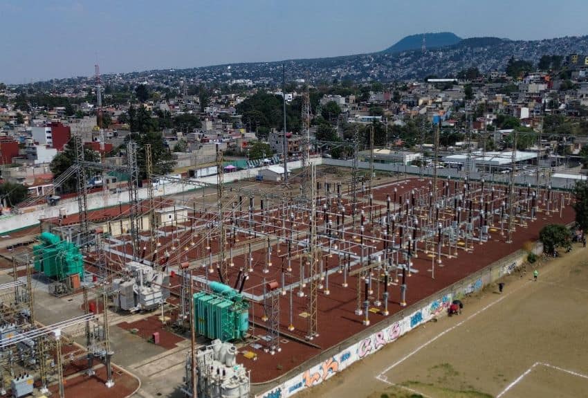 Electricity substation in Mexico surroundied by an urban landscape in the background.