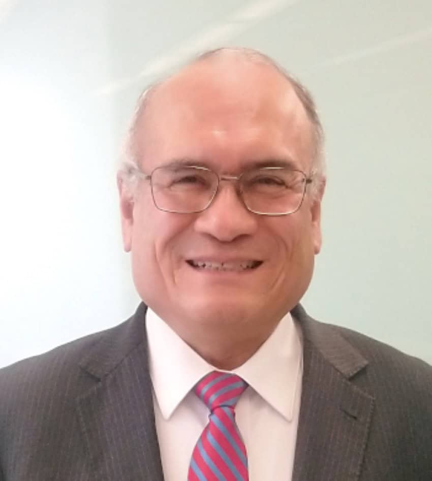 Dr. Salvador Landeros, head of the Mexican Space Agency. A middle-aged Mexican man wearing a suit and tie and posing for a publicity photo. He is wearing wire-rimmed glasses and smiling.