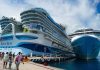 A massive cruise ship towers over a dock in Cozumel, Mexico while passengers cue to board