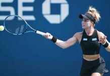 Mexican professional tennis player Renata Zarazua in a black tennis outfit and her blonde hair tired up in a bun, hitting a tennis ball with a forehand swing during a match.