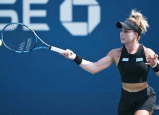 Mexican professional tennis player Renata Zarazua in a black tennis outfit and her blonde hair tired up in a bun, hitting a tennis ball with a forehand swing during a match.