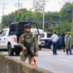 A Mexican soldier stands guard with a gun on a highway in Tabasco