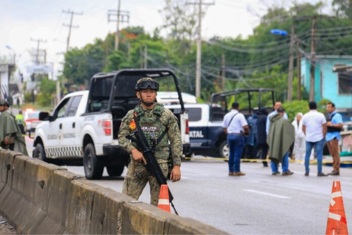 A Mexican soldier stands guard with a gun on a highway in Tabasco