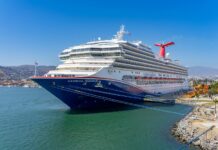 A blue and white Carnival cruise ship in the port of Ensenada, Mexico