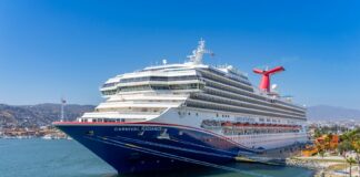A blue and white Carnival cruise ship in the port of Ensenada, Mexico