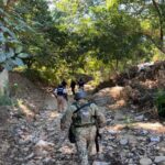 Soldiers walking through a wooded area