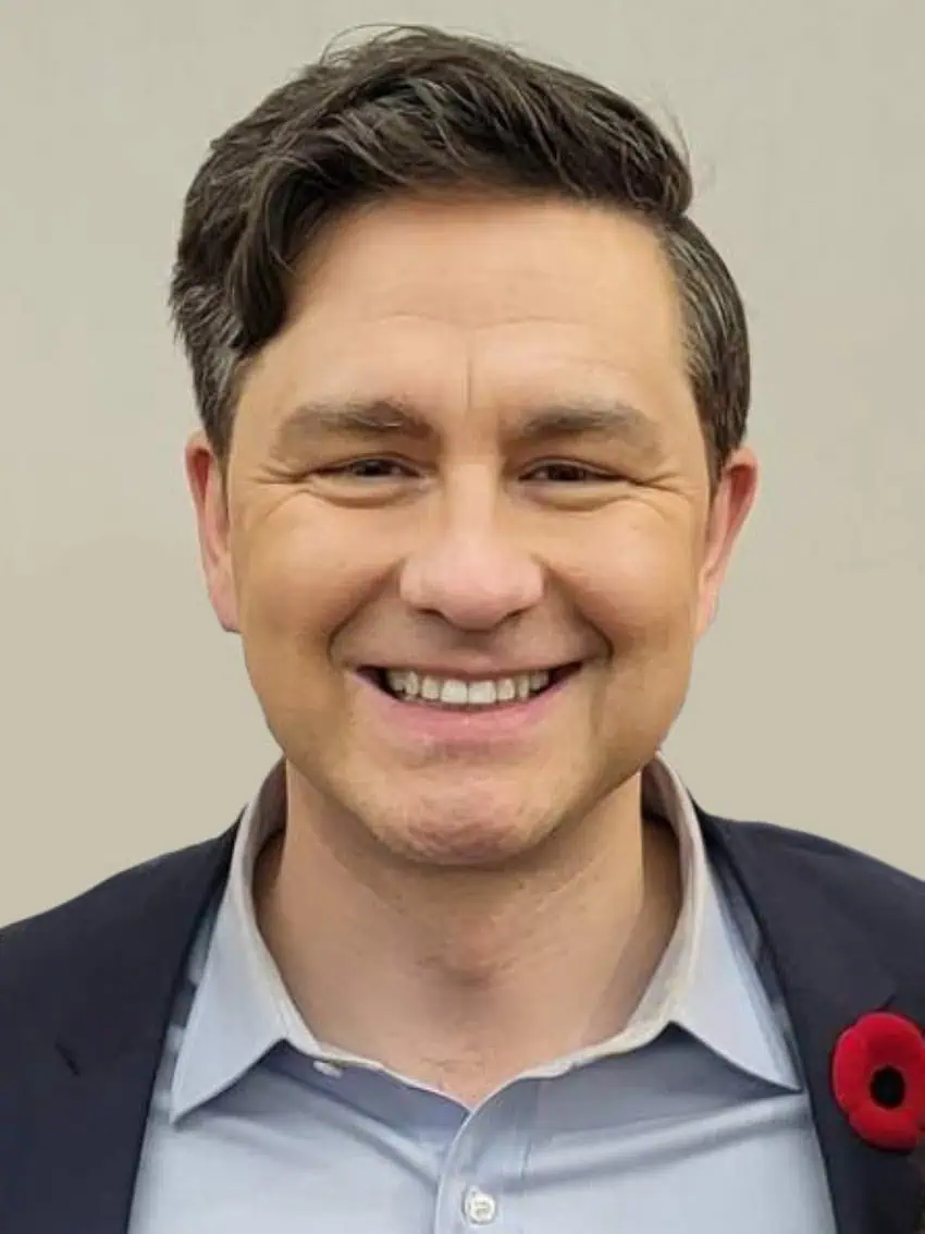 Posed shot of Pierre Poilievre, smiling in a light blue Oxford shirt and navy blue blazer.