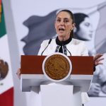 Sheinbaum disputes NYT fentanyl report: Thursday’s mañanera recapped Mexico's President Claudia Sheinbaum standing at the presidential podium during her press conference. Her mouth is open in speech and her eyes are wide and round and she's gripping the podium.