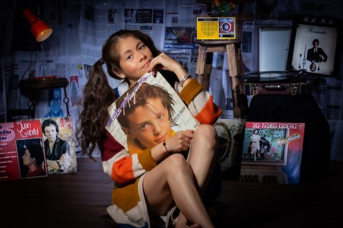 A young girl named Susy poses with her favorite vinyls of Mexican pop stars.