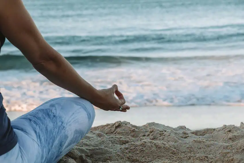 A person in lotus position meditating by the beach