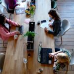 Women typing at shared desk in a co-working space