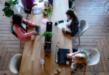 Women typing at shared desk in a co-working space