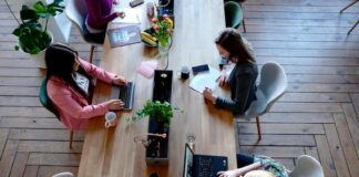 Women typing at shared desk in a co-working space
