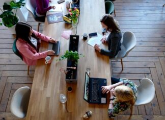 Women typing at shared desk in a co-working space