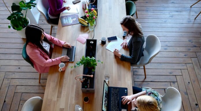 Women typing at shared desk in a co-working space