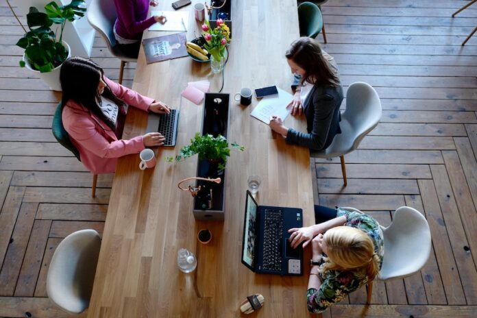 Women typing at shared desk in a co-working space