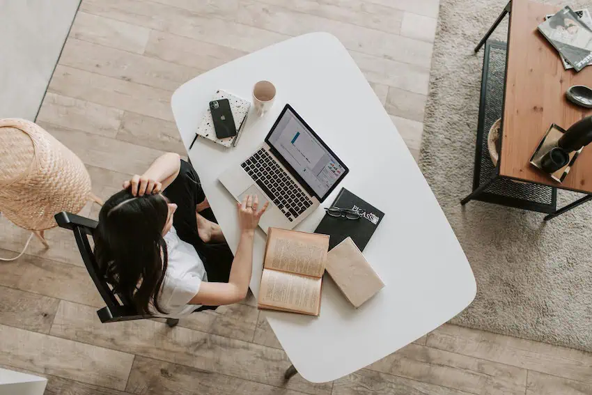 Bird's eye view of woman using laptop at desk in a co-working space