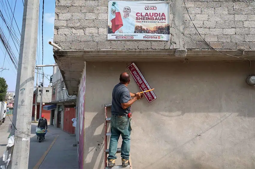 A man takes down a street sign in México state