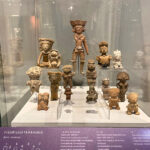 Clay figures of women in a museum display case