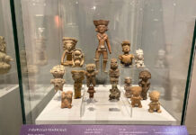 Clay figures of women in a museum display case