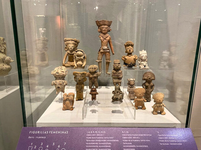 Clay figures of women in a museum display case