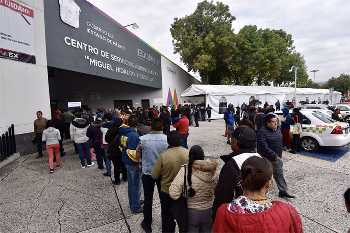 A long line of Toluca residents waits to file paperwork at a government office in Mexico