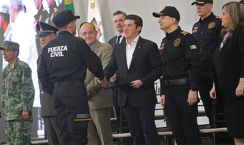 Nuevo León Governor Samuel García shakes the hand of a Fuerza Civil state police officer