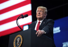 U.S. President Trump speaks at a podium in front of an American flag