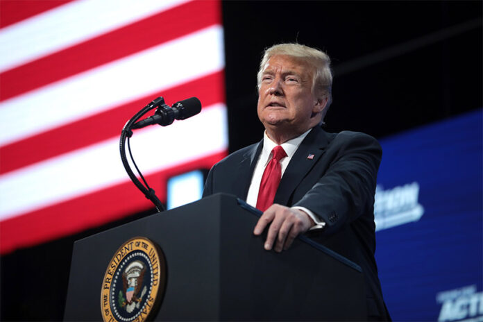 U.S. President Trump speaks at a podium in front of an American flag