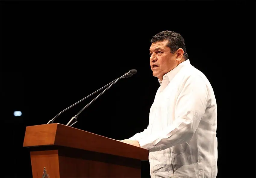 Tabasco Gov. Javier May speaks into a microphone on a stage