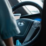 The steering wheel of a Chinese car showing the logo BYD