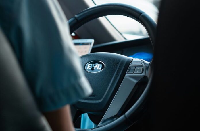 The steering wheel of a Chinese car showing the logo BYD