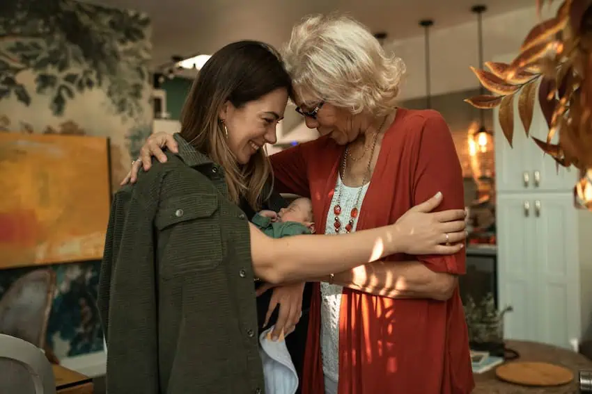 A woman, her baby and her mother-in-law in a warm embrace