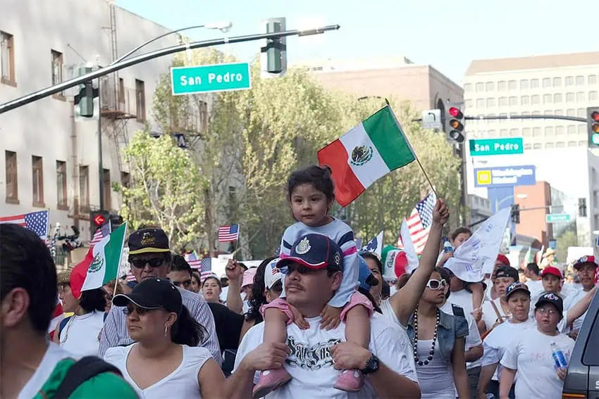 Families march with Mexican and U.S. flags in California