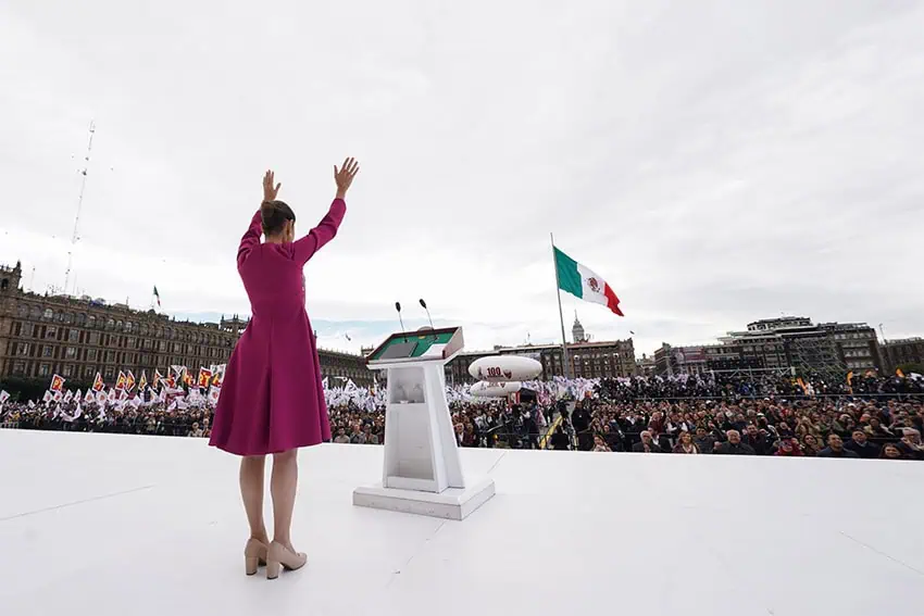 President Claudia Sheinbaum waves to the crowd at Mexico City's Zócalo during her 100-day address on Sunday