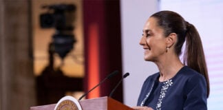 President Claudia Sheinbaum smiles in a side profile photo taken during her mañanera press conference