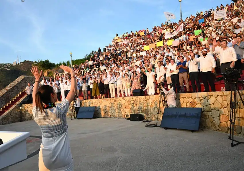 Sheinbaum waves to a crowd standing in a cliffside outdoor theater in Acapulco