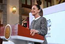 President Sheinbaum stands a podium during her morning press conference, where she discussed flights eliminated by Mexicana airline and other topics.