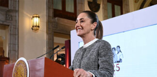 President Sheinbaum stands a podium during her morning press conference, where she discussed flights eliminated by Mexicana airline and other topics.